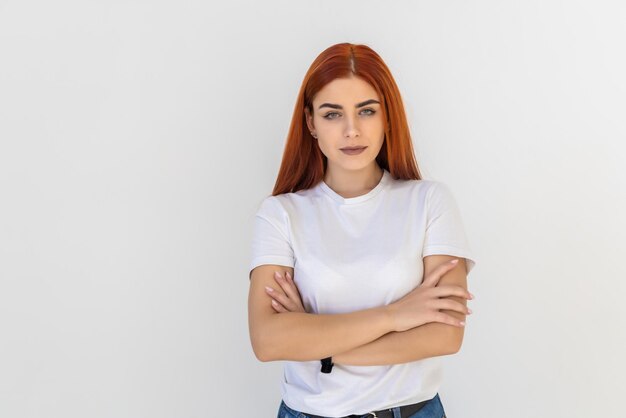 Smiling redhead woman blue eyes standing profile self-assured pose hands crossed chest turning face left amused intereste