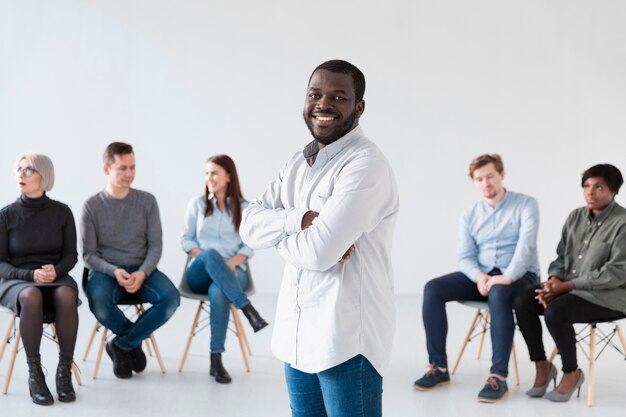 Smiling rehab patients standing with crossed hands