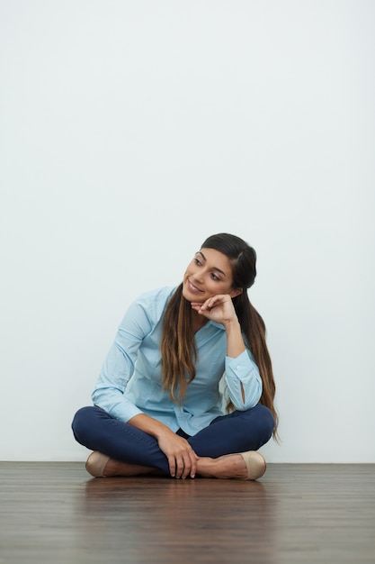 Foto gratuita sorridente rilassato bella donna seduta sul pavimento