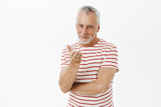 Smiling romantic elderly husband sending air kiss