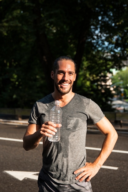 Smiling runner holding water bottle