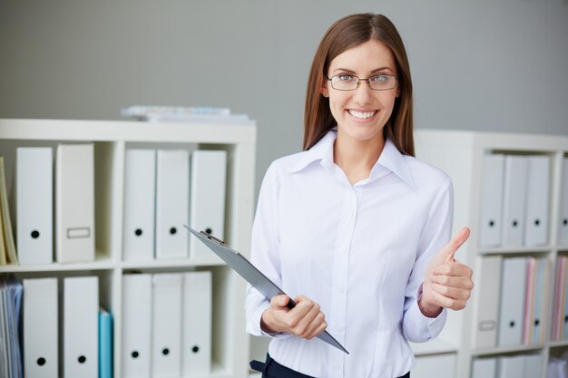 Smiling secretary with glasses and thumbs up