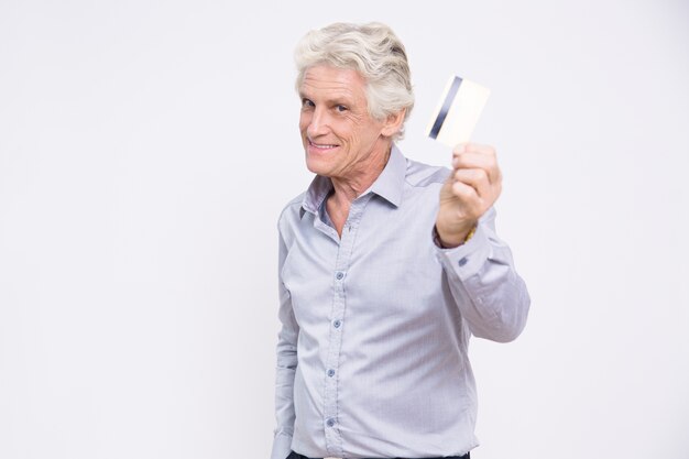 Smiling senior businessman holding credit card