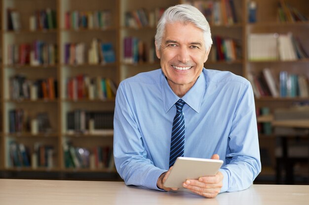 Smiling senior businessman using digital tablet