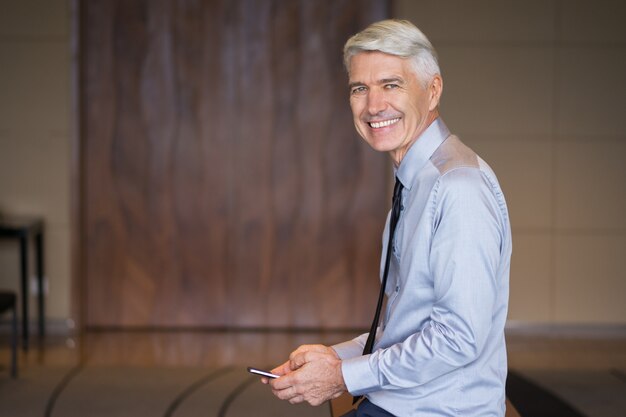 Smiling Senior Businessman Using Smartphone