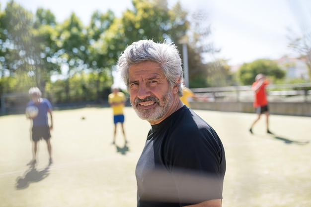 Free photo smiling senior goalkeeper ready for match. caucasian man with grey hair and beard looking at camera. football, sport, leisure concept