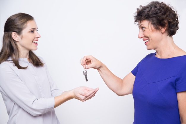 Sorridente madre senior dando chiavi per la figlia