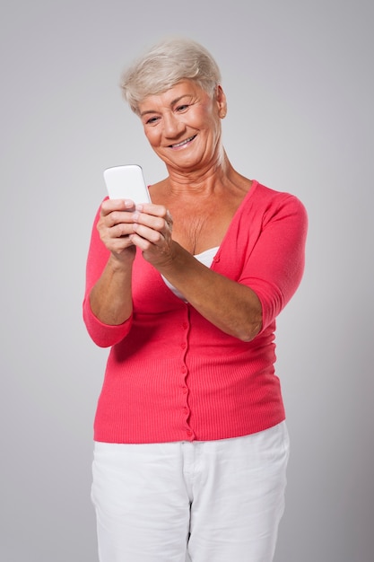 Sorridente donna senior utilizza lo smartphone