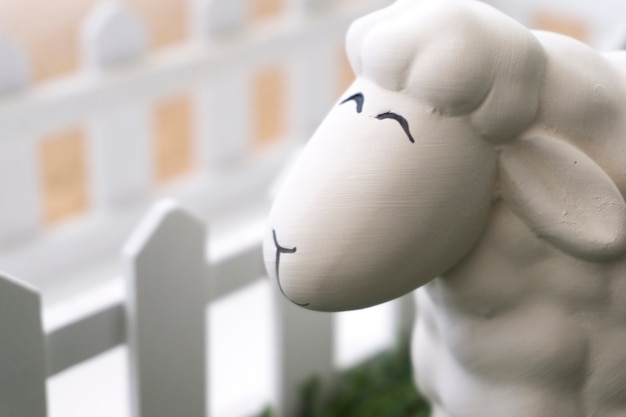 Smiling sheep with wooden fence background