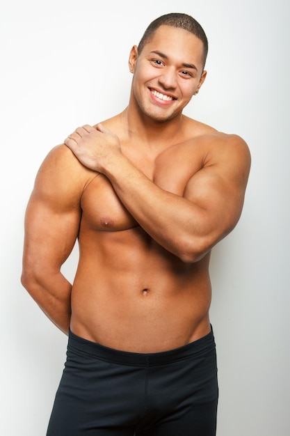 Smiling shirtless guy in studio on white background