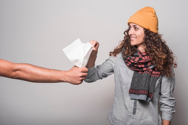 Donna ammalata sorridente che cattura la carta velina dalla mano dell'uomo