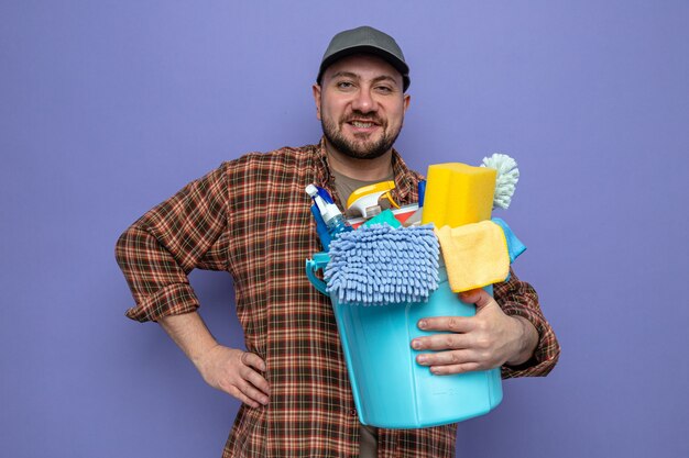 Smiling slavic cleaner man holding cleaning equipment and 