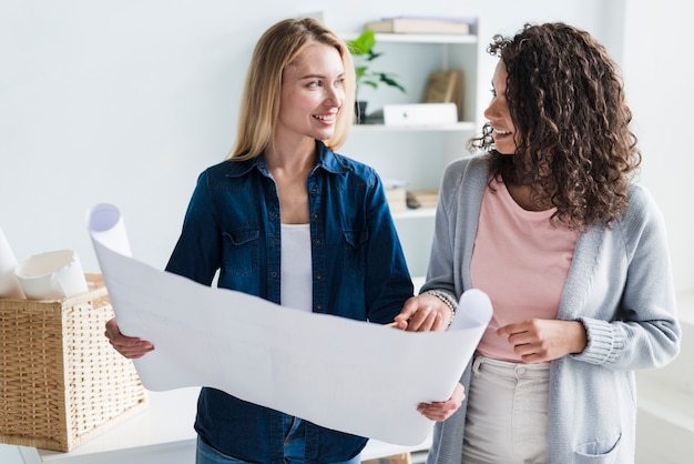 Foto gratuita progettisti astuti sorridenti del collega che discutono lavoro