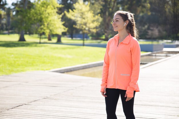 Smiling sporty woman relaxing in city park