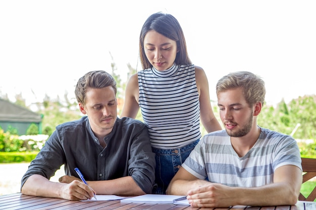 Smiling students doing homework with girlfriend