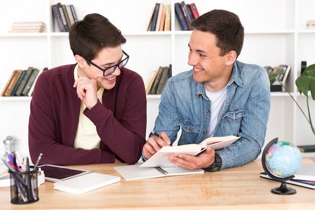 Smiling students reading book