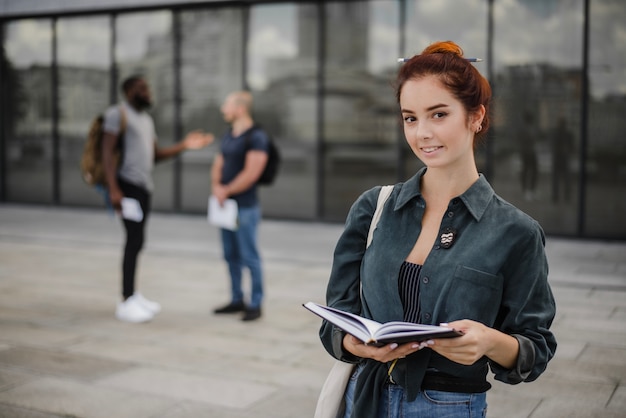 Smiling students standing with notepad