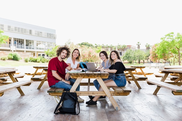 Free photo smiling students studying together at table