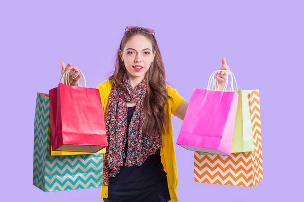 Smiling stylish woman showing colorful paper bag