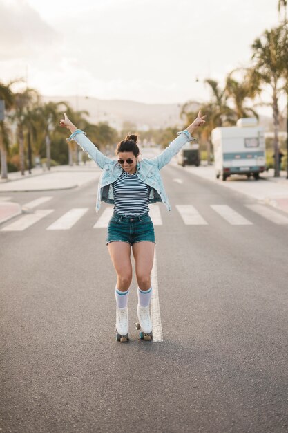 세련 된 젊은 여자 도로에 입고 롤러 스케이트 균형 조정