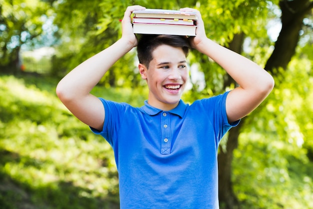 Улыбающийся мальчик-подросток с книгами