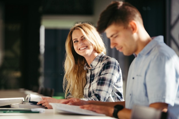 Smiling teen girl with boy in library