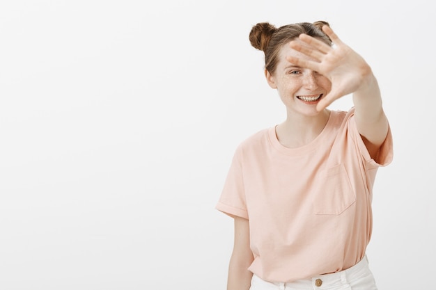 Free photo smiling teenage girl posing against the white wall