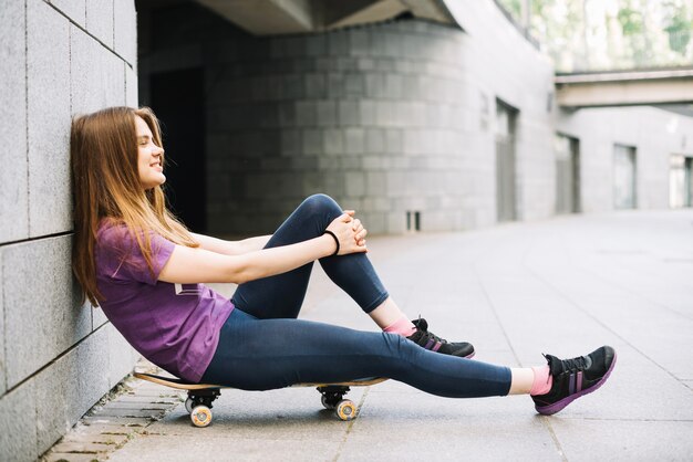 Smiling teenager embracing her knee