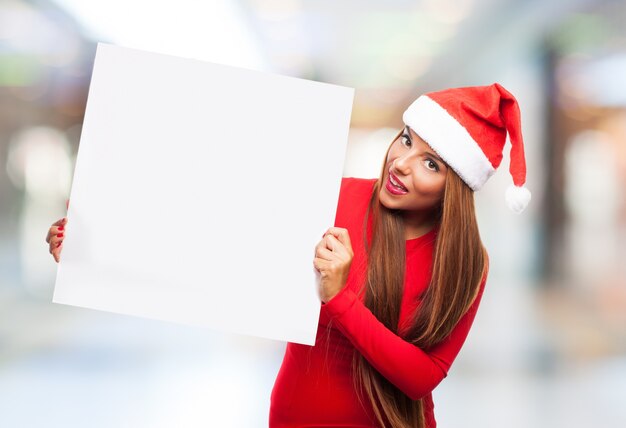 Smiling teenager posing with a blank sign on blurred background