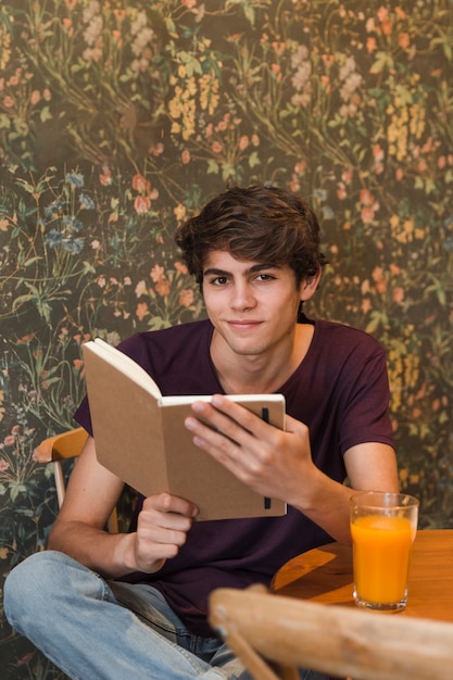 Smiling teenager reading in cafe