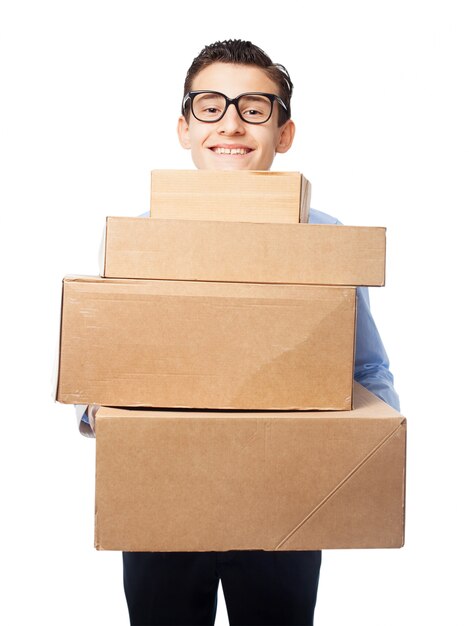 Smiling teenager with glasses carrying boxes