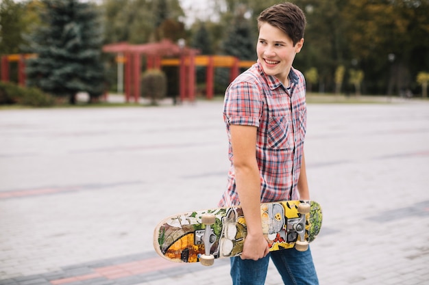 Smiling teenager with skateboard