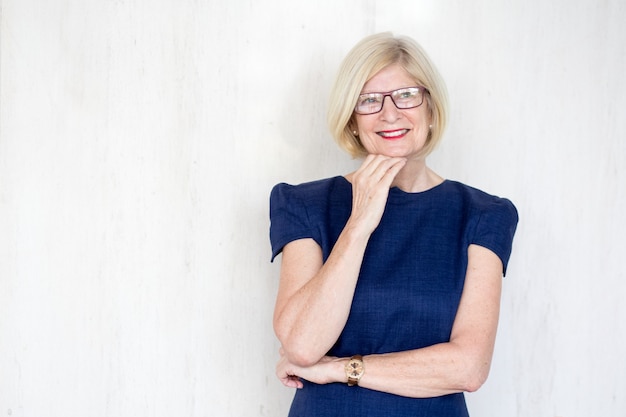 Smiling thoughtful senior woman in eyeglasses