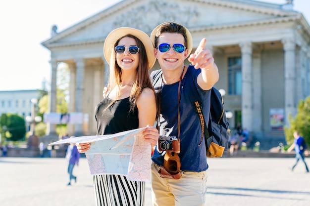 Coppie turistiche sorridenti che fanno un giro turistico nella città