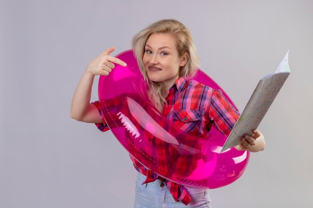 Foto gratuita la ragazza sorridente del viaggiatore che porta la camicia rossa in punti gonfiabili dell'anello da mappare su fondo bianco isolato