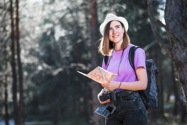 Smiling traveller with map and camera