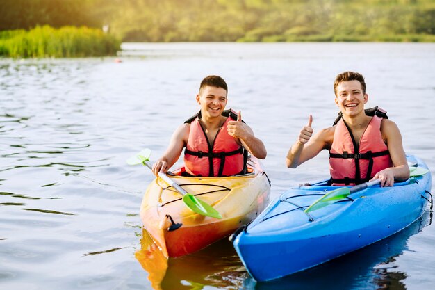 Un kayaker maschio sorridente due che mostra pollice sul segno