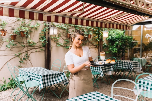 Free photo smiling waitress holding tray