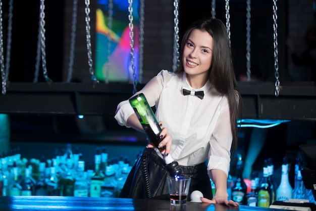 Smiling waitress preparing a glass