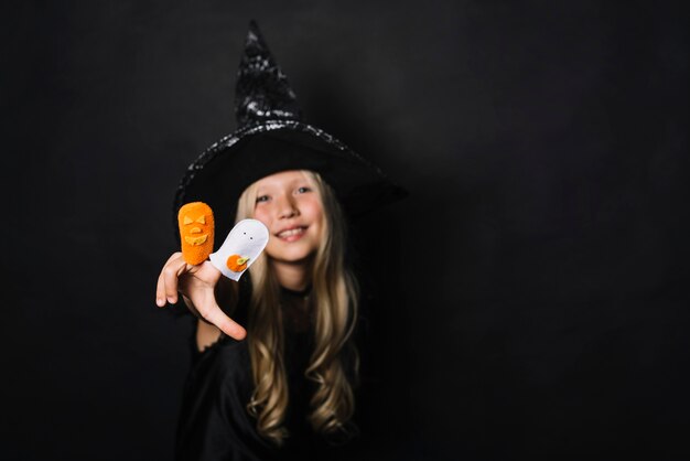 Smiling witch showing Halloween toys