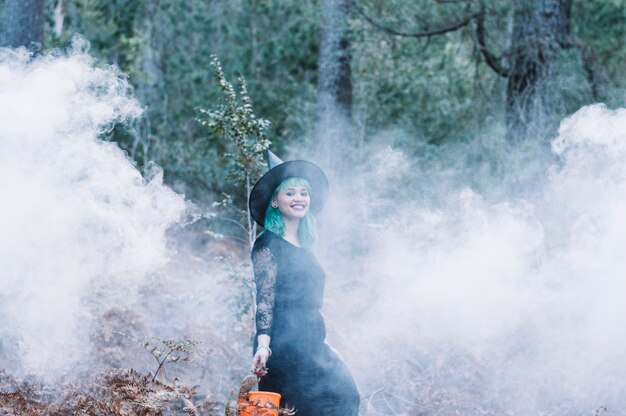 Smiling witch standing in smoke