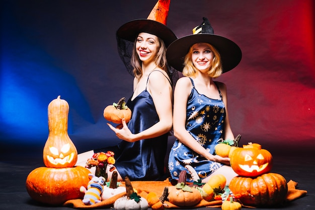 Smiling wItches holding pumpkins 