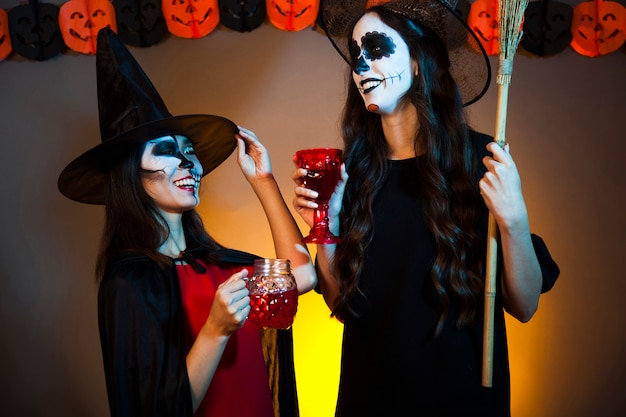 Smiling witches with drinks at a party