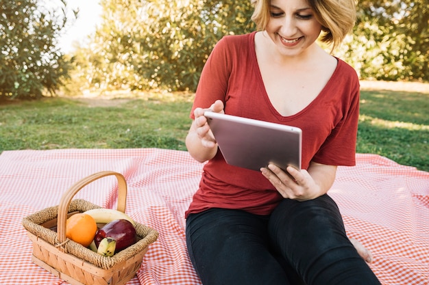 Foto gratuita compressa sorridente di lettura rapida della donna sul picnic