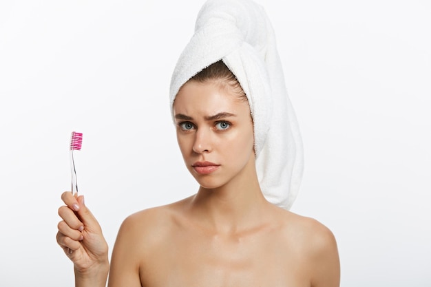 Улыбающаяся женщина чистит зубы полотенцем на голове, отличная улыбка