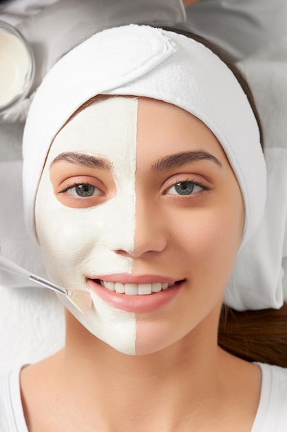 Smiling woman on cleaning face in beautician