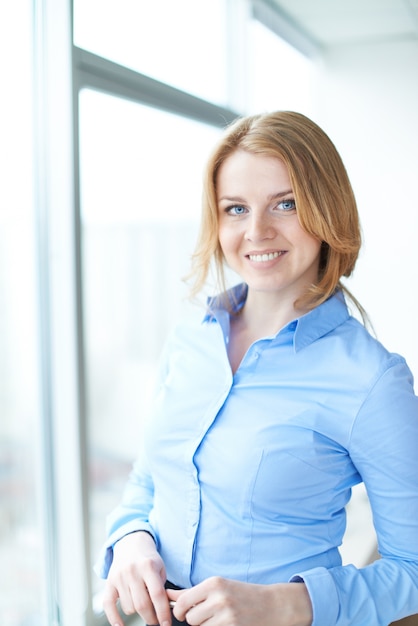 Free photo smiling woman close to a window