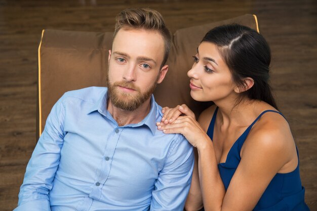 Smiling woman consoling her stressed boyfriend