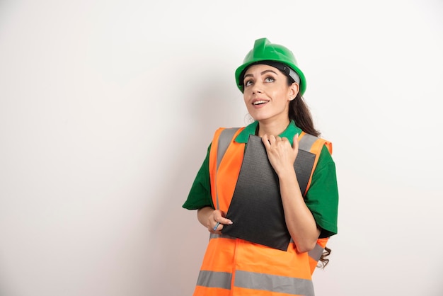 Smiling woman constructor with clipboard on white background. High quality photo