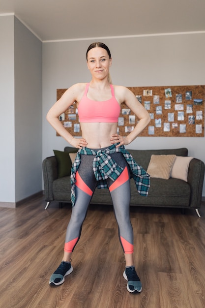 Smiling woman dancing in the middle of the living room enjoying herself and life